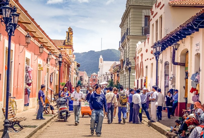 Vibrant Streets of Real de Guadalupe Photograph by Bill Bell An image showcasing the lively pedestrian street Real de Guadalupe, lined with colorful colonial buildings, bustling cafes, and artisans displaying their crafts.