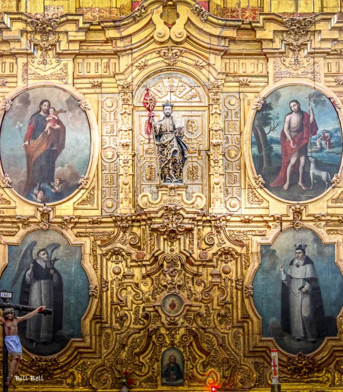 The ornate altar inside the Mission of San Ignacio, Baja California Sur, is a stunning example of Baroque artistry. Lavishly decorated with gold leaf and religious icons, it showcases intricate carvings and painted portraits of saints. The centerpiece includes a figure holding a symbol of faith, surrounded by paintings that narrate biblical scenes and stories of revered saints, offering a glimpse into the spiritual heritage and devotion of this historic mission.