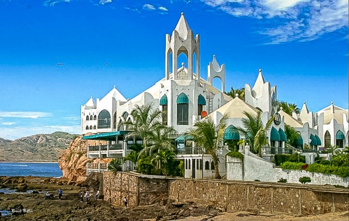 The iconic architecture of Mazatlán's El Faro (The Lighthouse) Resort perched dramatically on the edge of the rocky coastline, offering stunning views of the Pacific Ocean