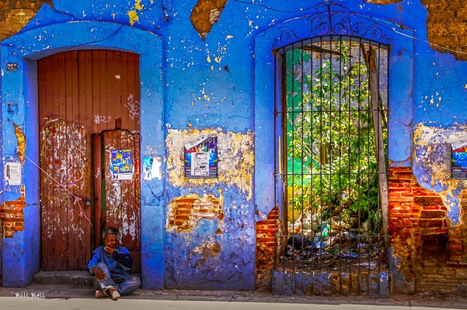 A Colorful Ruin in Oaxaca: A weathered blue facade with chipped paint and crumbling brick, a symbol of Oaxaca’s rich, layered history, offering a glimpse into both the past and the present.