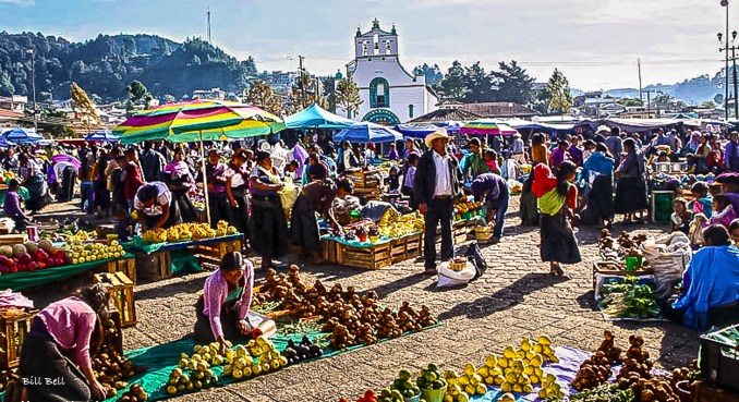 The Bustling Market of Chamula Photograph by Bill Bell A vibrant scene from the market in Chamula, where locals gather under colorful umbrellas to sell fresh produce and handmade crafts. The backdrop of the town’s church adds a cultural touch, making it a perfect place to experience the local life of the Tzotzil people.