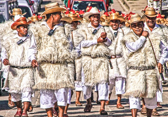 Traditional Parade in Chamula Photograph by Bill Bell A festive procession of Chamula men dressed in traditional white wool ponchos and straw hats. Their cheerful expressions and spirited walk highlight the community's rich cultural heritage during one of the many annual festivities celebrated in the town.