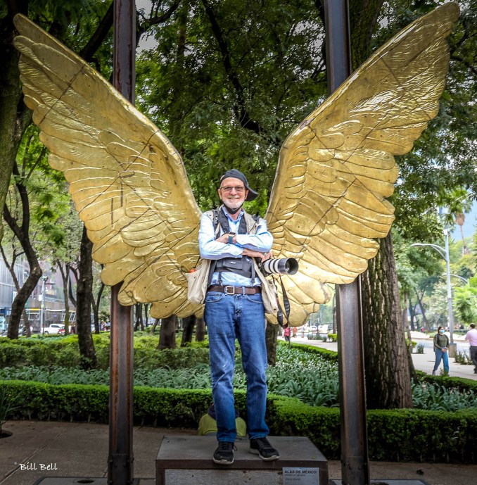 Wings of Mexico: Photographer Bill Bell poses in front of the famous "Alas de México" (Wings of Mexico) statue in Paseo de la Reforma, a popular symbol of hope and freedom.