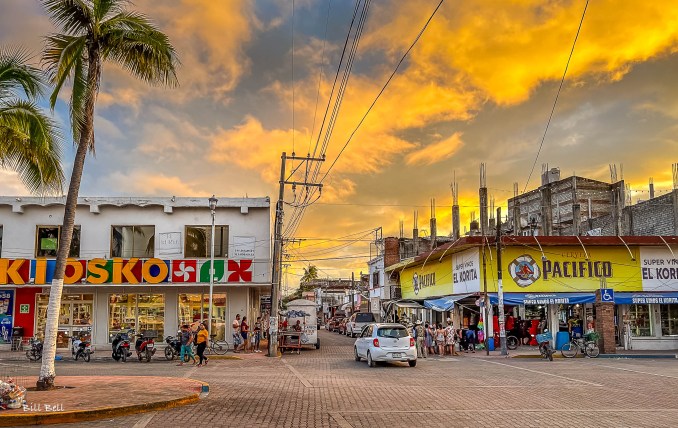  The bustling streets of La Peñita de Jaltemba at sunset, where local shops and restaurants come alive under a sky painted with vibrant colors.