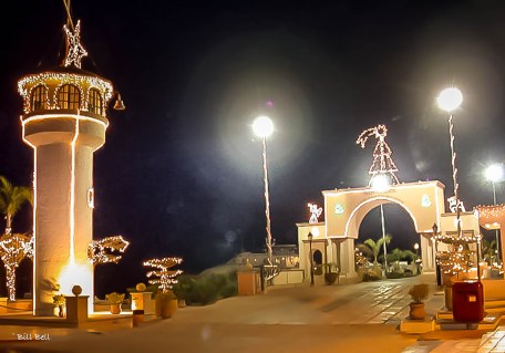 The iconic lighthouse and festive decorations light up the entrance to La Paz's waterfront, creating a magical atmosphere during the holiday season.