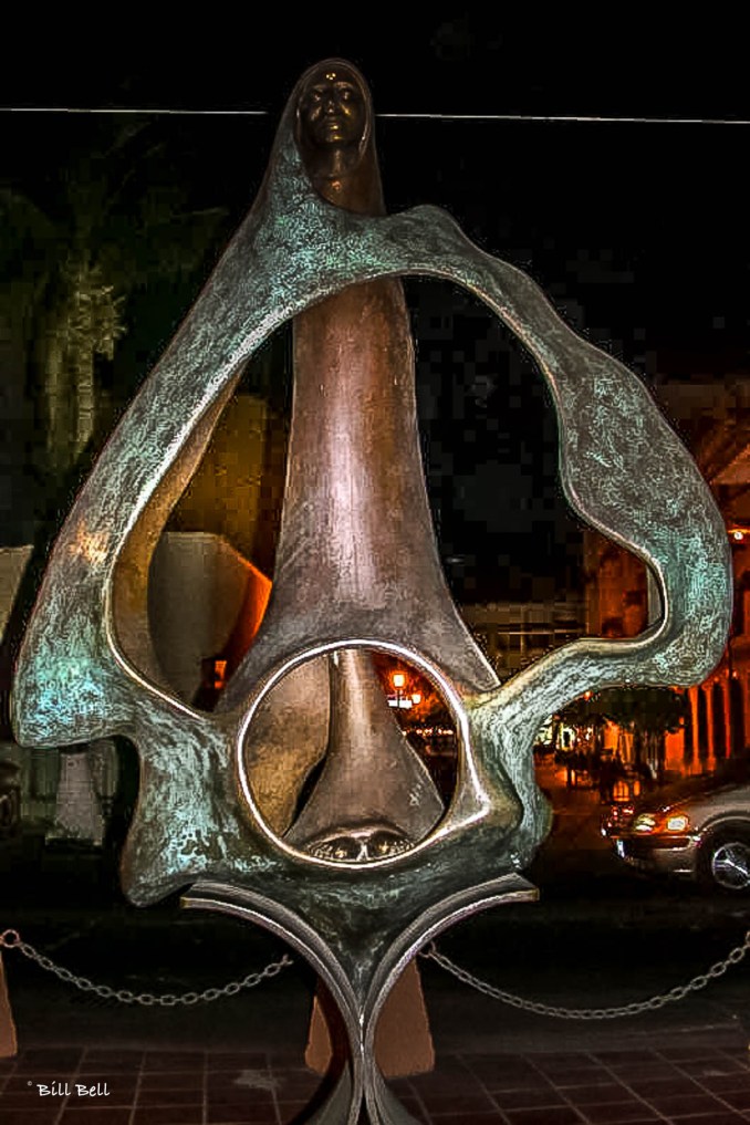  An artistic bronze sculpture graces the Malecón of La Paz, capturing the spirit of the city through its flowing lines and elegant form, beautifully illuminated against the night sky.