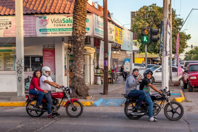 Locals in Los Mochis, Sinaloa, enjoy a casual ride through town on their motorcycles, capturing the laid-back yet lively street life. Vida Saludable and nearby shops reflect the town's growing urban culture