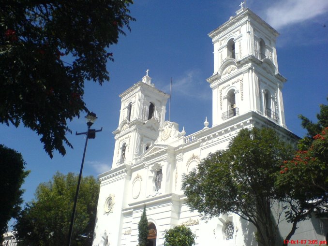  The majestic Cathedral of Santa María de la Asunción in Chilpancingo stands tall against a clear blue sky, showcasing its elegant white façade and twin bell towers. This historic cathedral is a testament to the city's rich religious heritage and architectural splendor, inviting visitors to explore its serene interior and reflect on its historical significance.