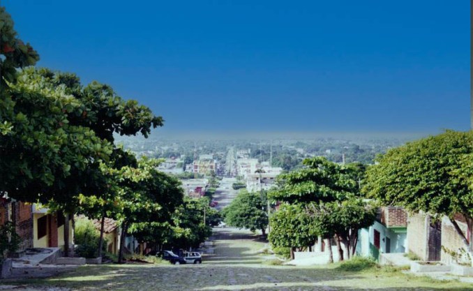 A picturesque view of Arriaga, Chiapas, showcasing its charming streets lined with lush greenery and the vibrant town center in the distance.