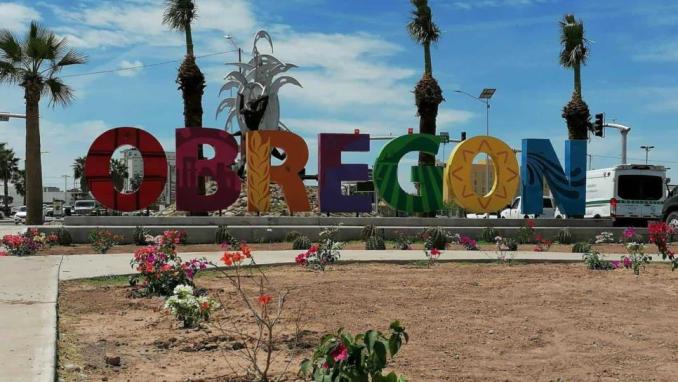 The colorful "Obregón" sign welcomes travelers to Ciudad Obregón, a vibrant stopover town on Highway 15. The sign, surrounded by blooming flowers and palm trees, is a popular spot for photos and symbolizes the warm hospitality of the city.