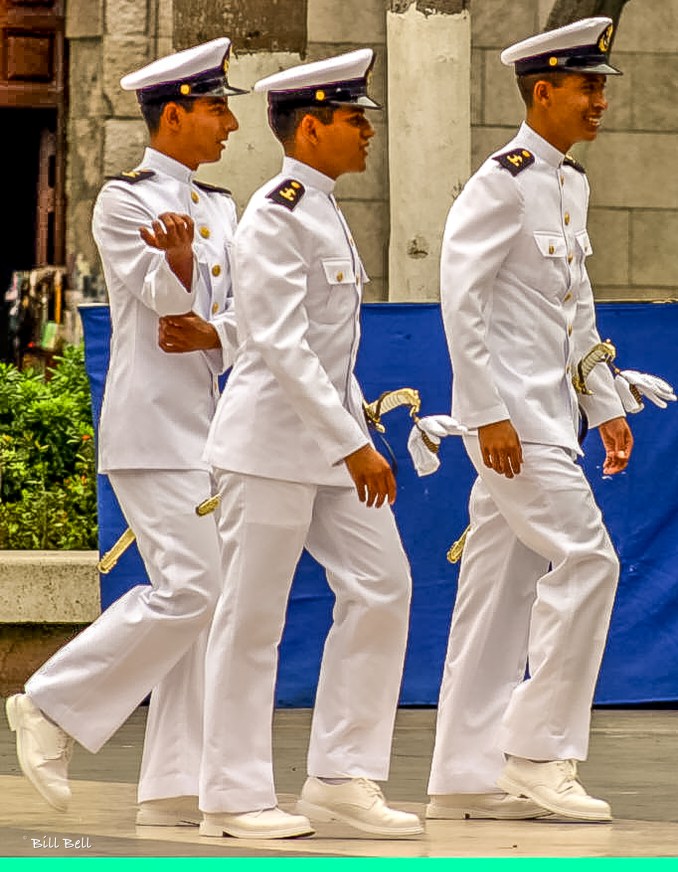 Young naval cadets in crisp white uniforms walk through Veracruz's bustling streets, embodying the city's strong naval presence and connection to the sea. Their uniforms are a common and distinctive sight in this lively port city. © Bill Bell